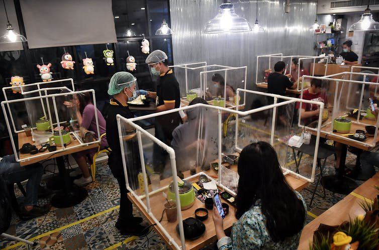 A restaurant in Bangkok created plastic partitions and moved its tables farther apart to separate guests in a normally tight space.