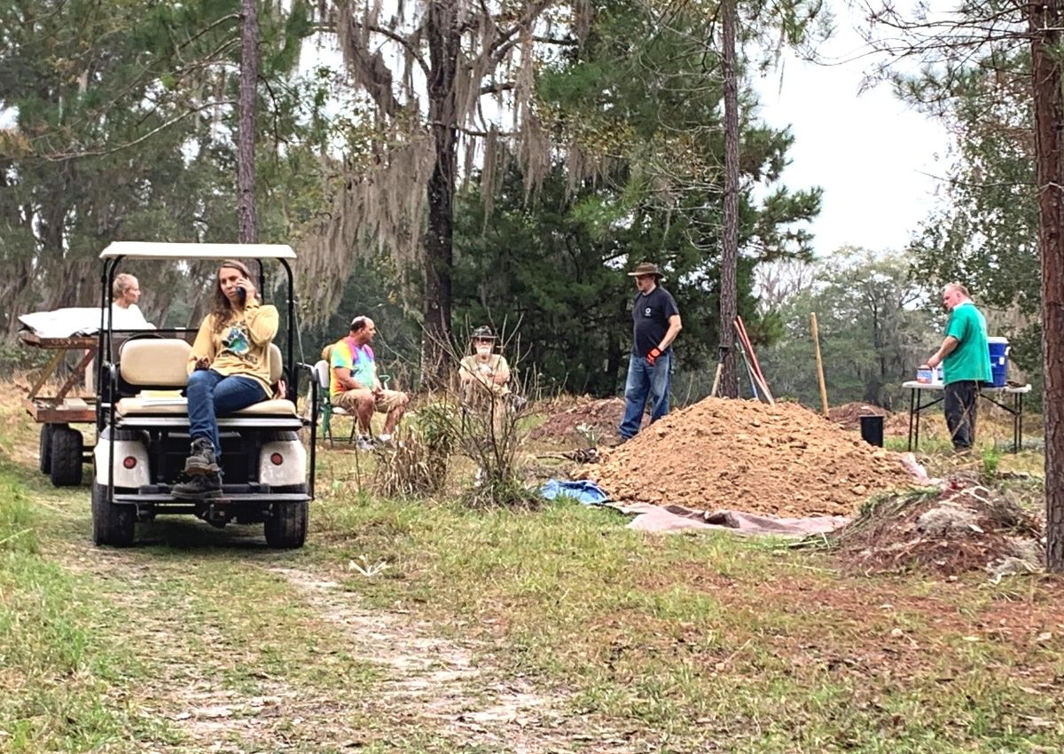 Jamie Westfall on phone with volunteers preparing gravesite