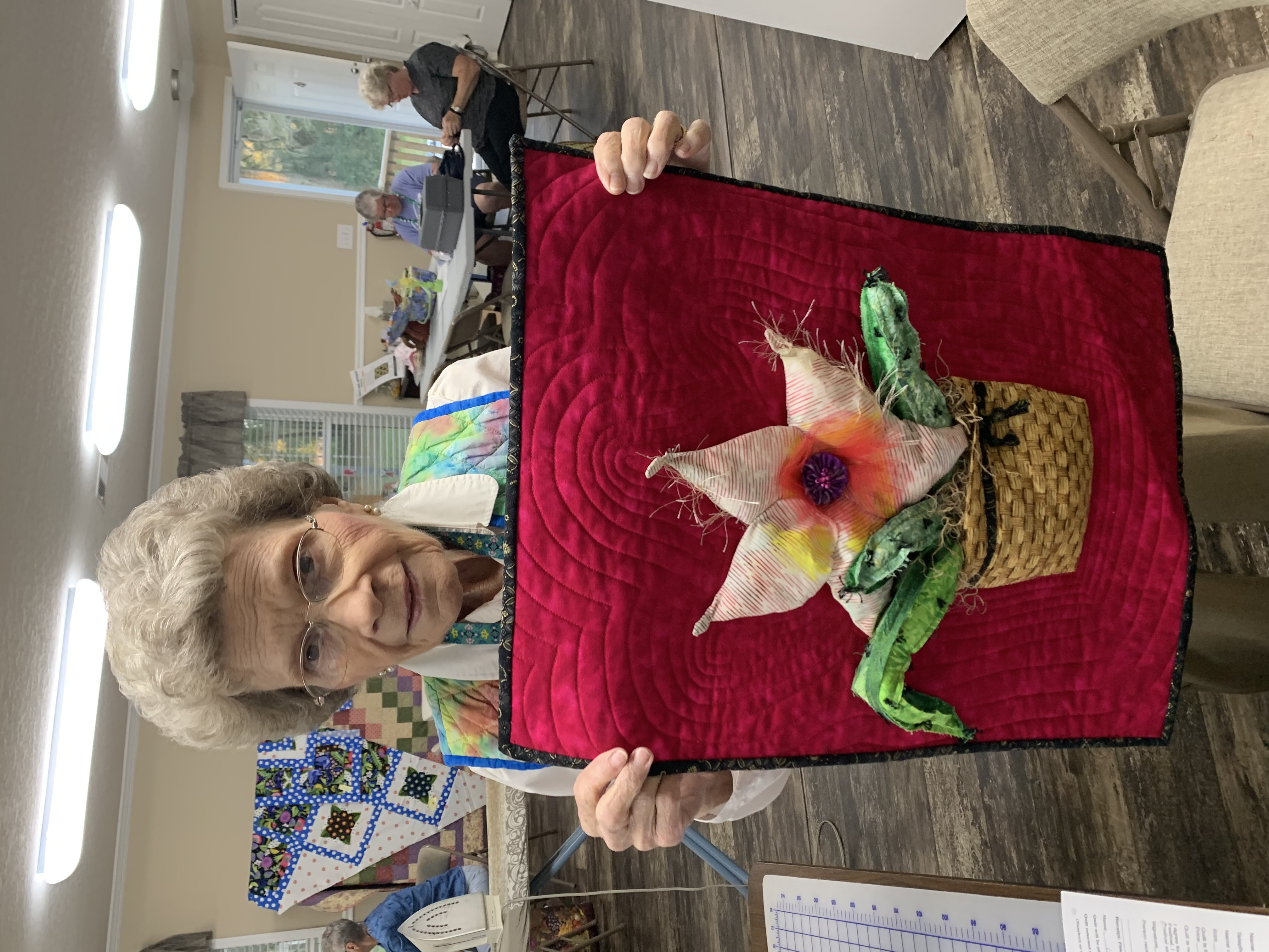 Lois Scott holding flower quilt