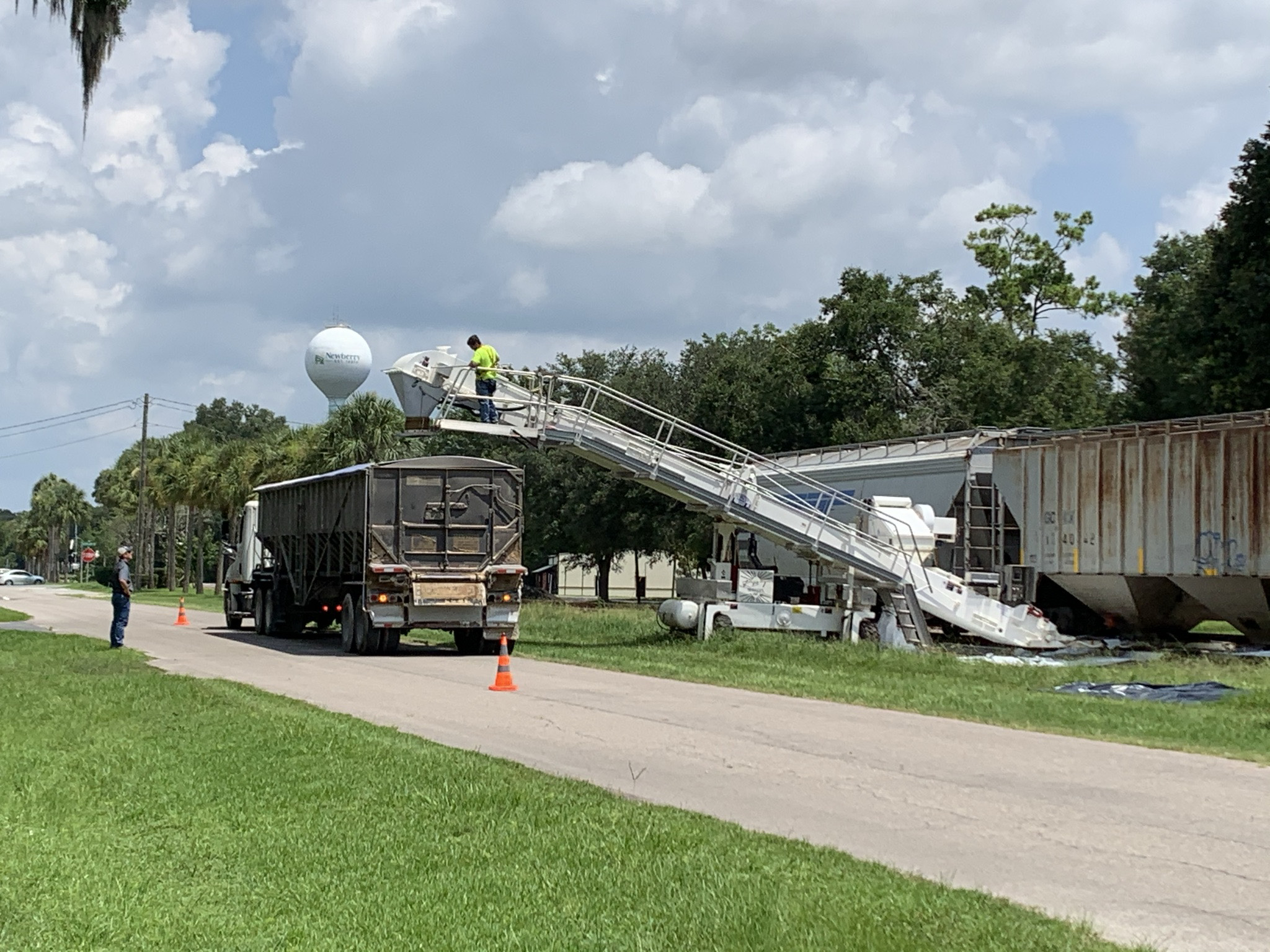 Workers use conveyor to load feed onto truck