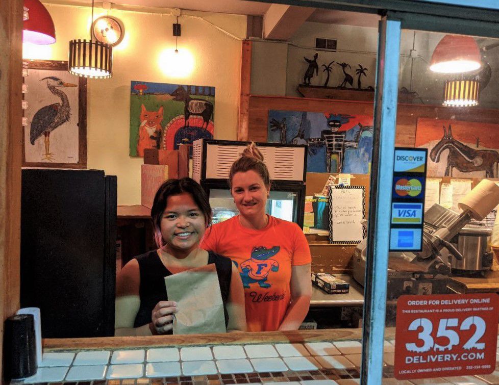 Ashley Garcia, left, and a co-worker serve a customer at the take-out window atFlaco's Cuban Bakery. atFlaco's.