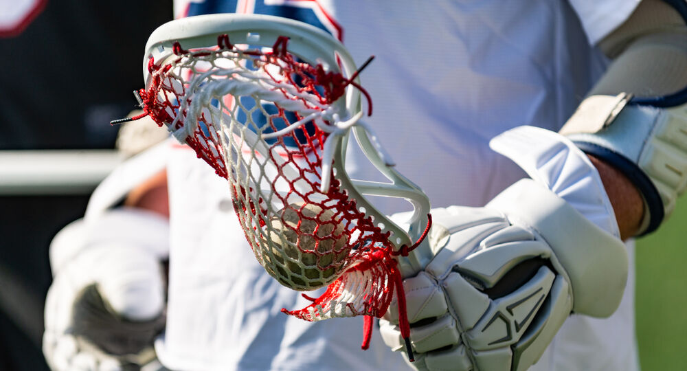 Close-up of a male lacrosse player holding his stick.
