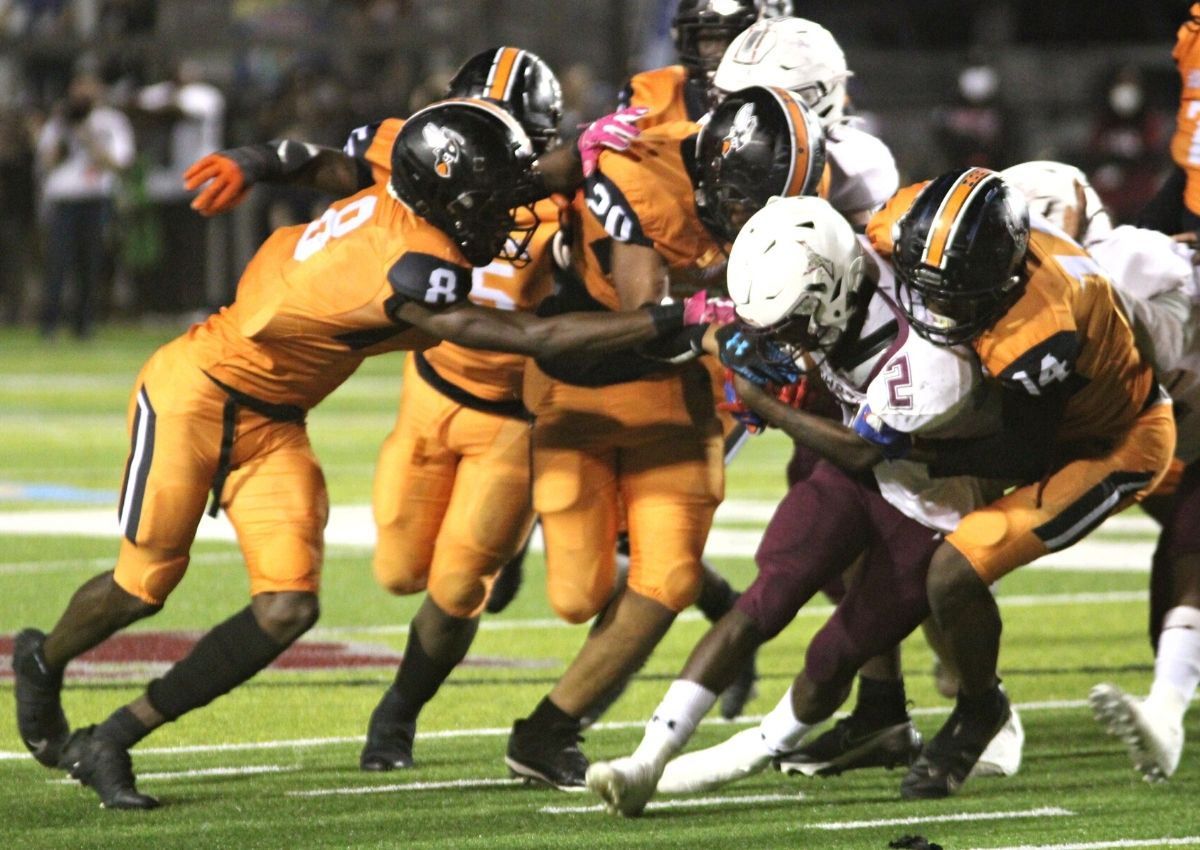 Hawthorne Jalien Ruth (14) Chris Jonas (8) and Amari Sheppard (20) tackle MC Tommie House