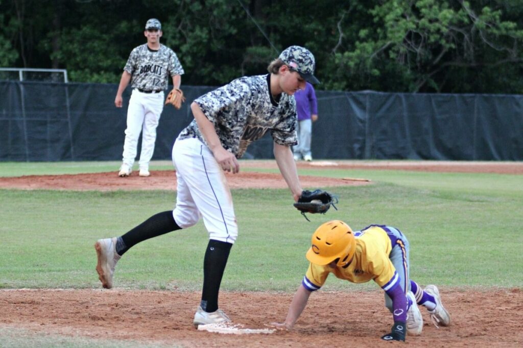 Columbia's Matt Dumas dives back to first base under Buchholz's Anthony Wilkie's tag attempt on Tuesday.