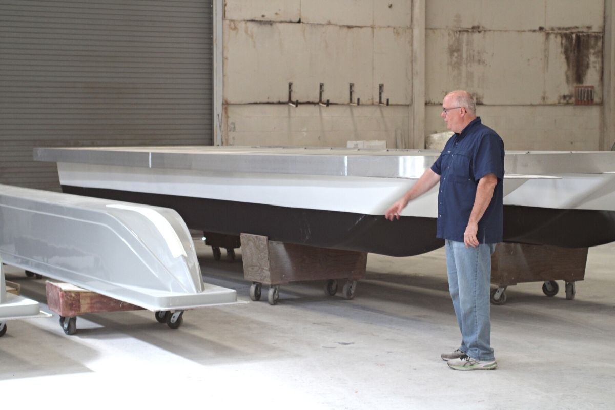 John Hemken A&M Manufacturing pointing out fiberglass hulls