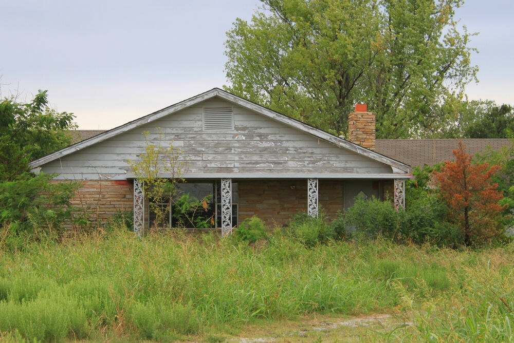Old house overgrown with grass