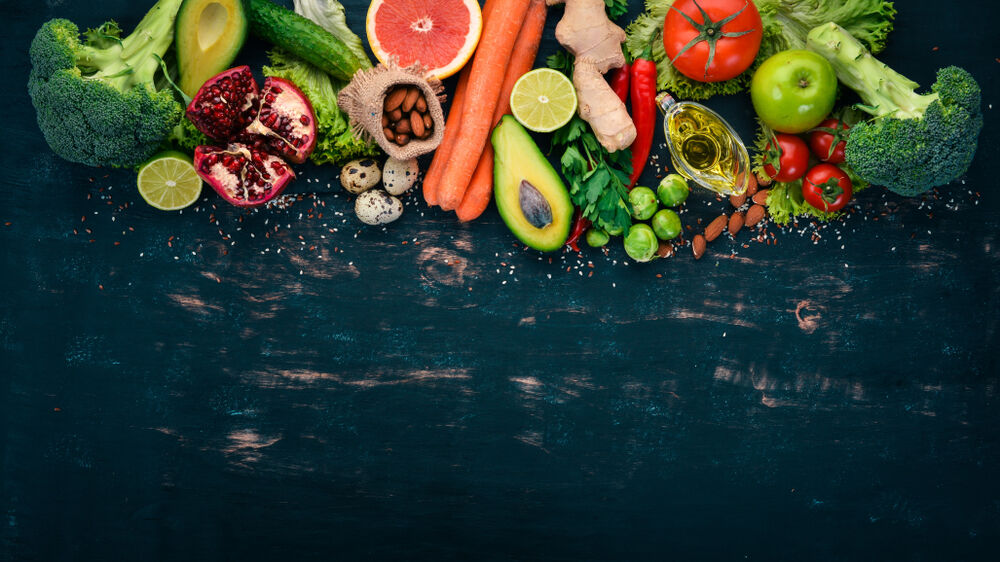 Healthy fruits and vegetables on black wooden table