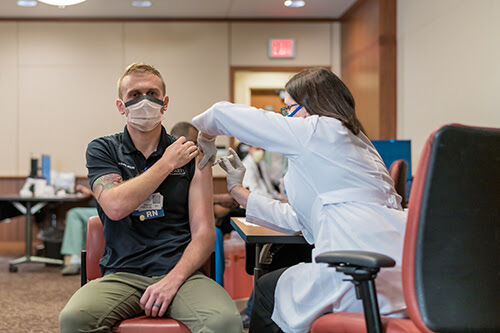 I think its a step toward getting back to some kind of normal, said Samuel J. Overly, B.S.N., R.N.-B.C., a trauma nurse and clinical leader in the UF Health adult emergency department, after receiving the inaugural vaccination. Credit: Louis Brems
