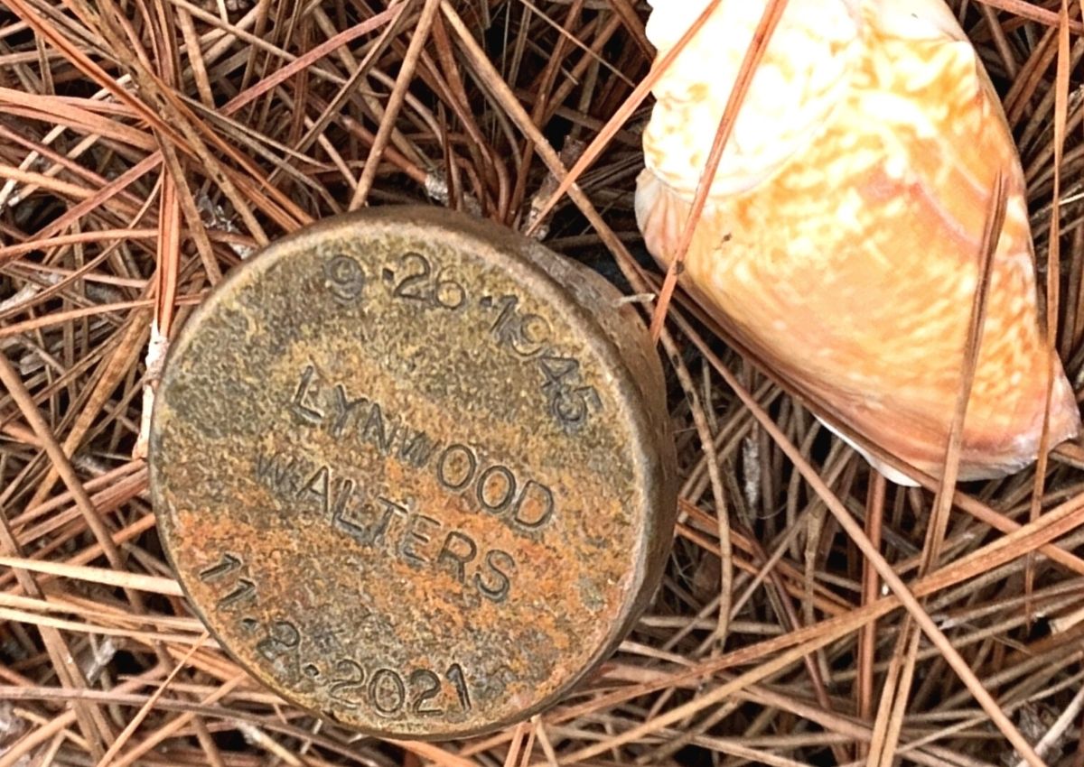 Brass marker hand labeled by PCCC staff identifies grave