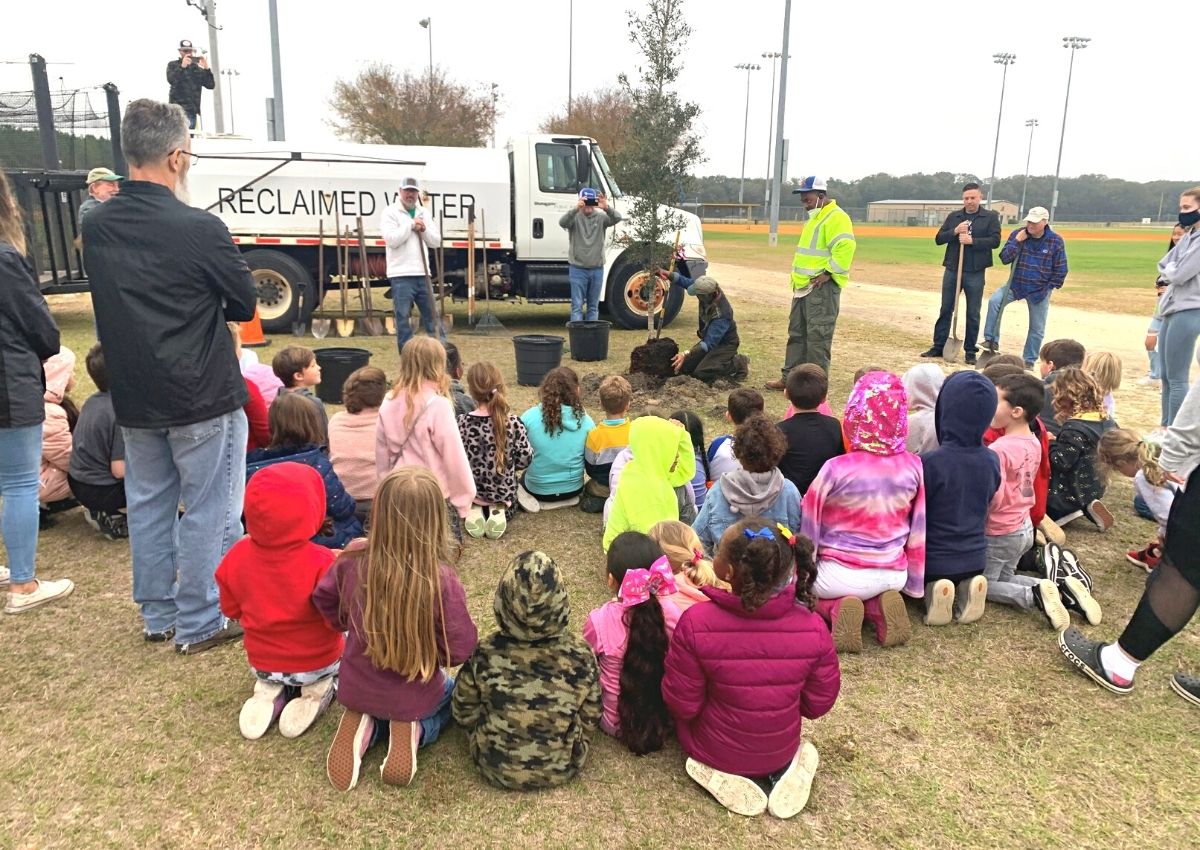 Alachua County arborist Lucy Holtzworth and Greenfield Preschool students at Easton Newberry Sports Complex