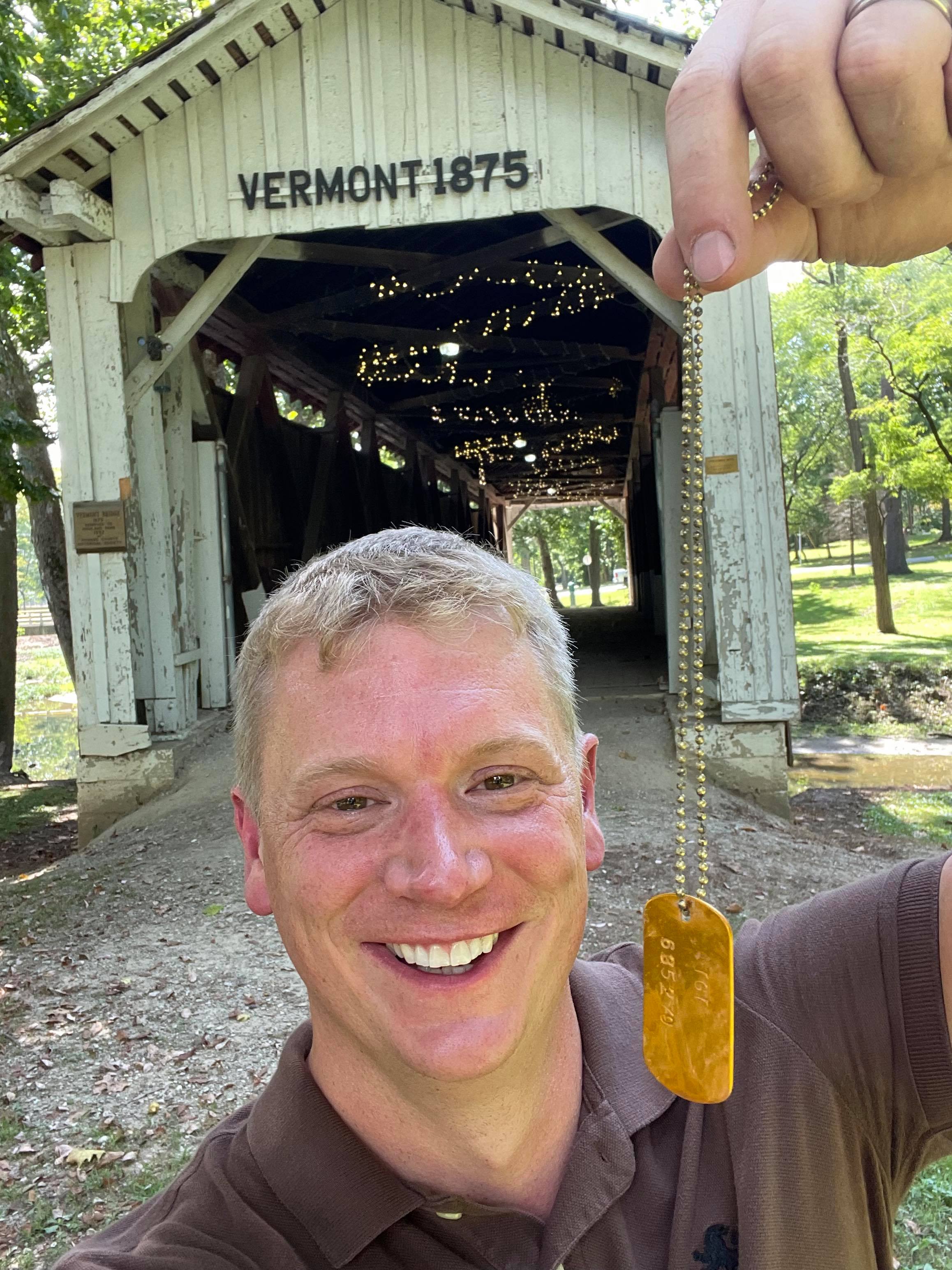 Andrew Maas holds up golden ticket with bridge in background