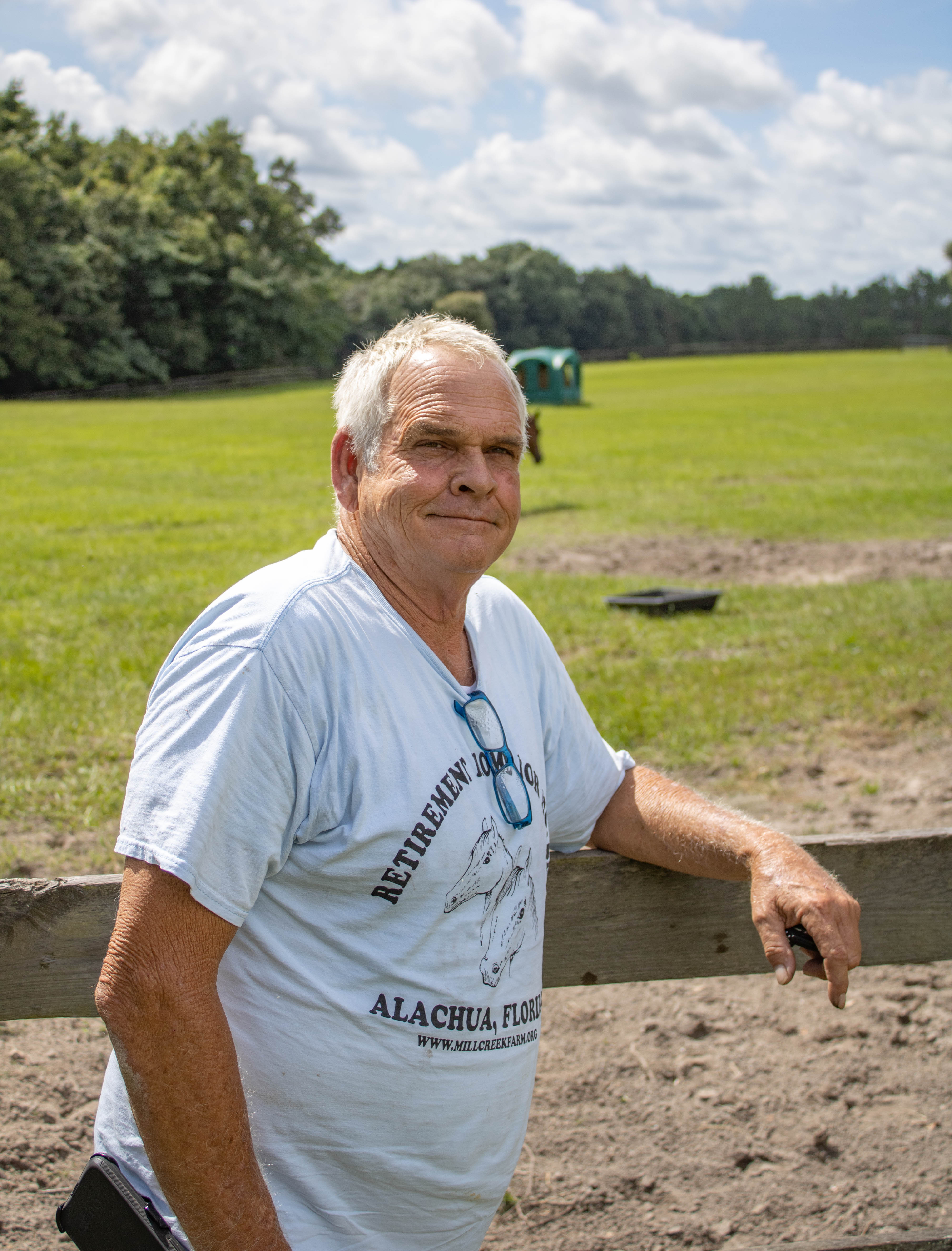 Paul Gregory, owner of Mill Creek Farm in Alachua, stands by a horse fence