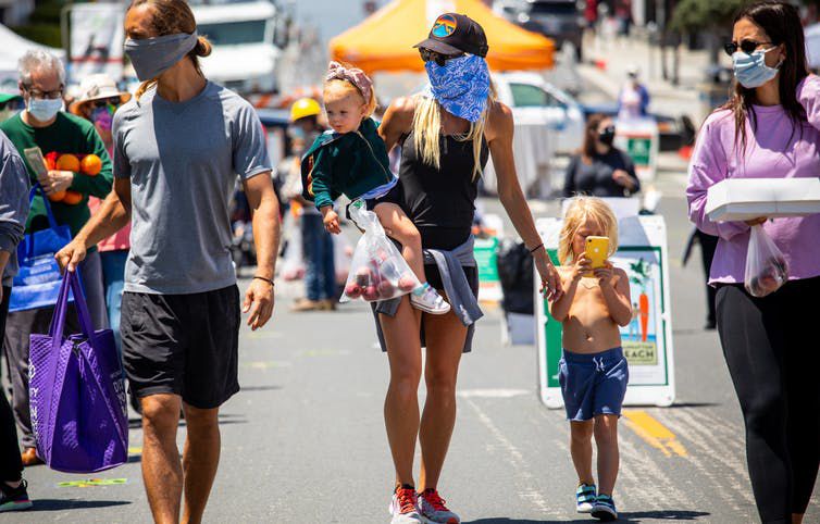 People shop at the re-opening of the Farmers Market in Manhattan Beach, Calif. on May 12, 2020.