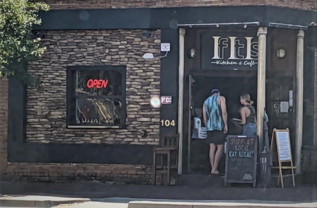 Customers check out the take-out menu outsideIf It Is Kitchen & Caf, 104 S. Main St. The Thai restaurant opened on July 1, 2018.