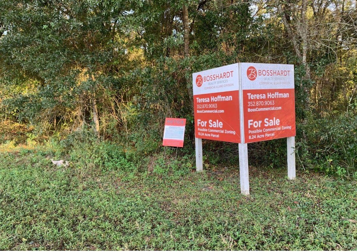 For sale sign at edge of woods