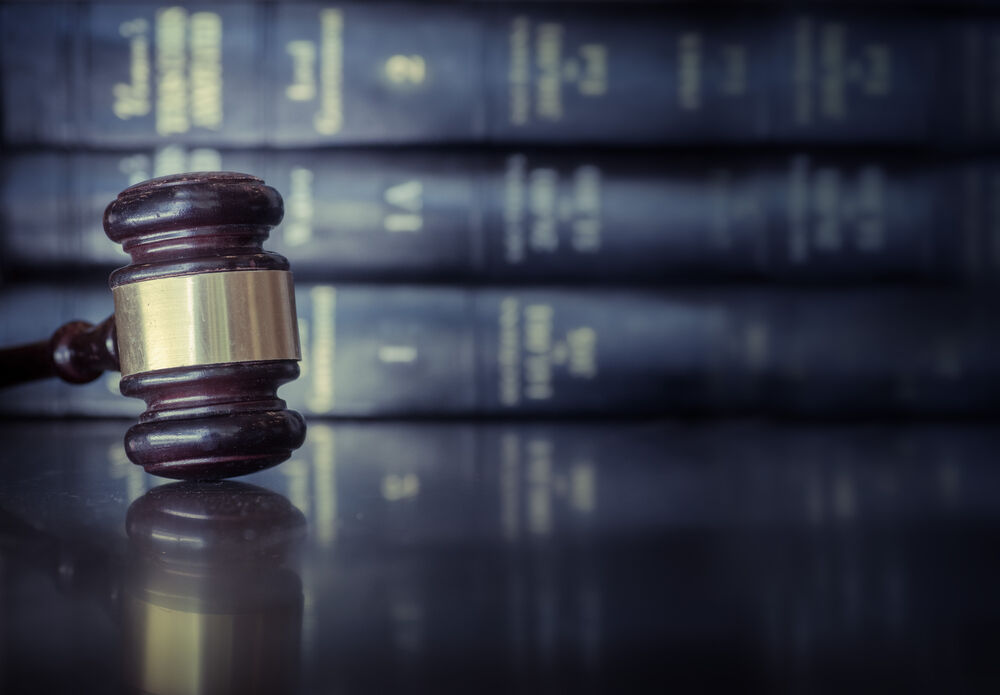 Wooden gavel on desk with books in background