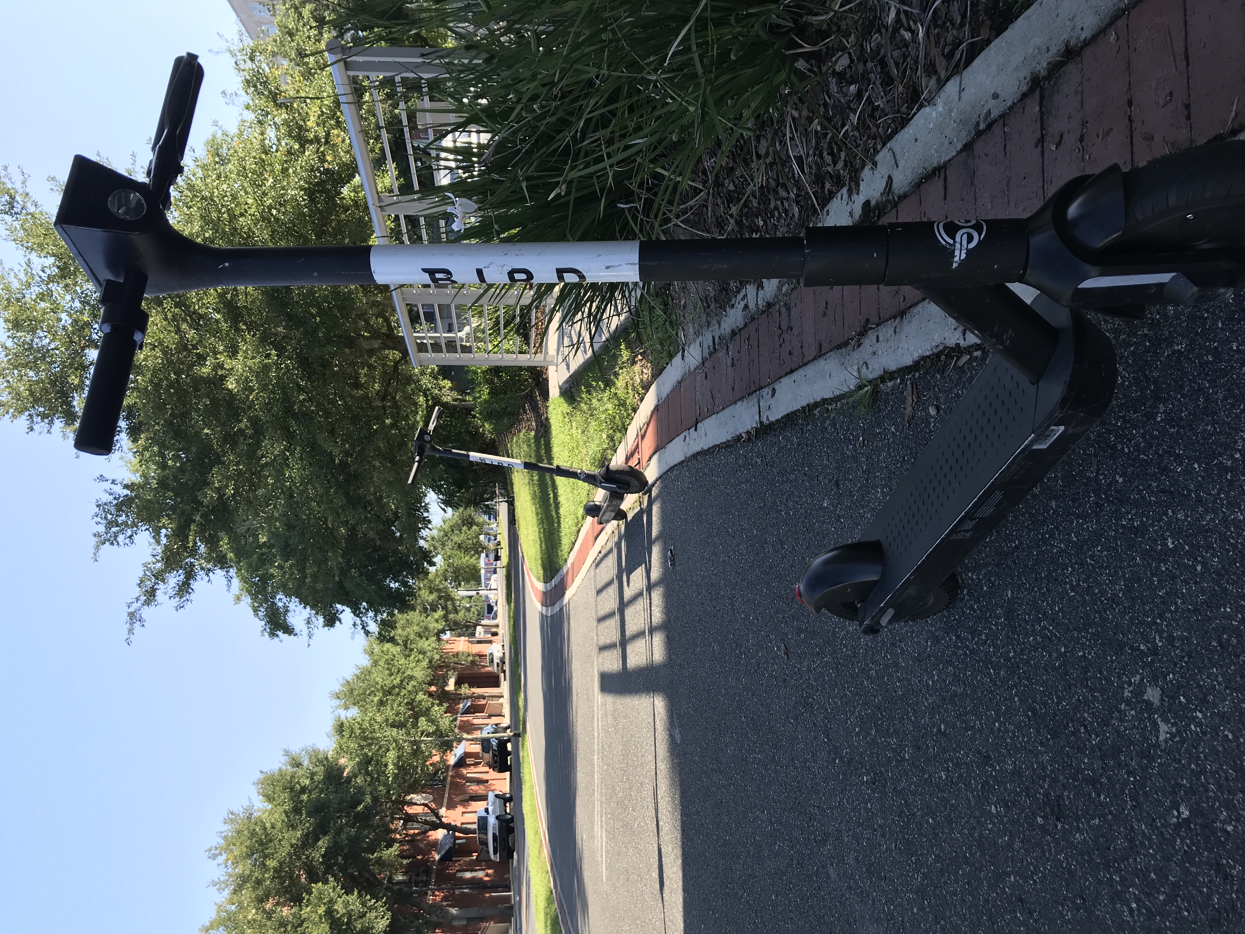 Two scooters parked on sidewalk