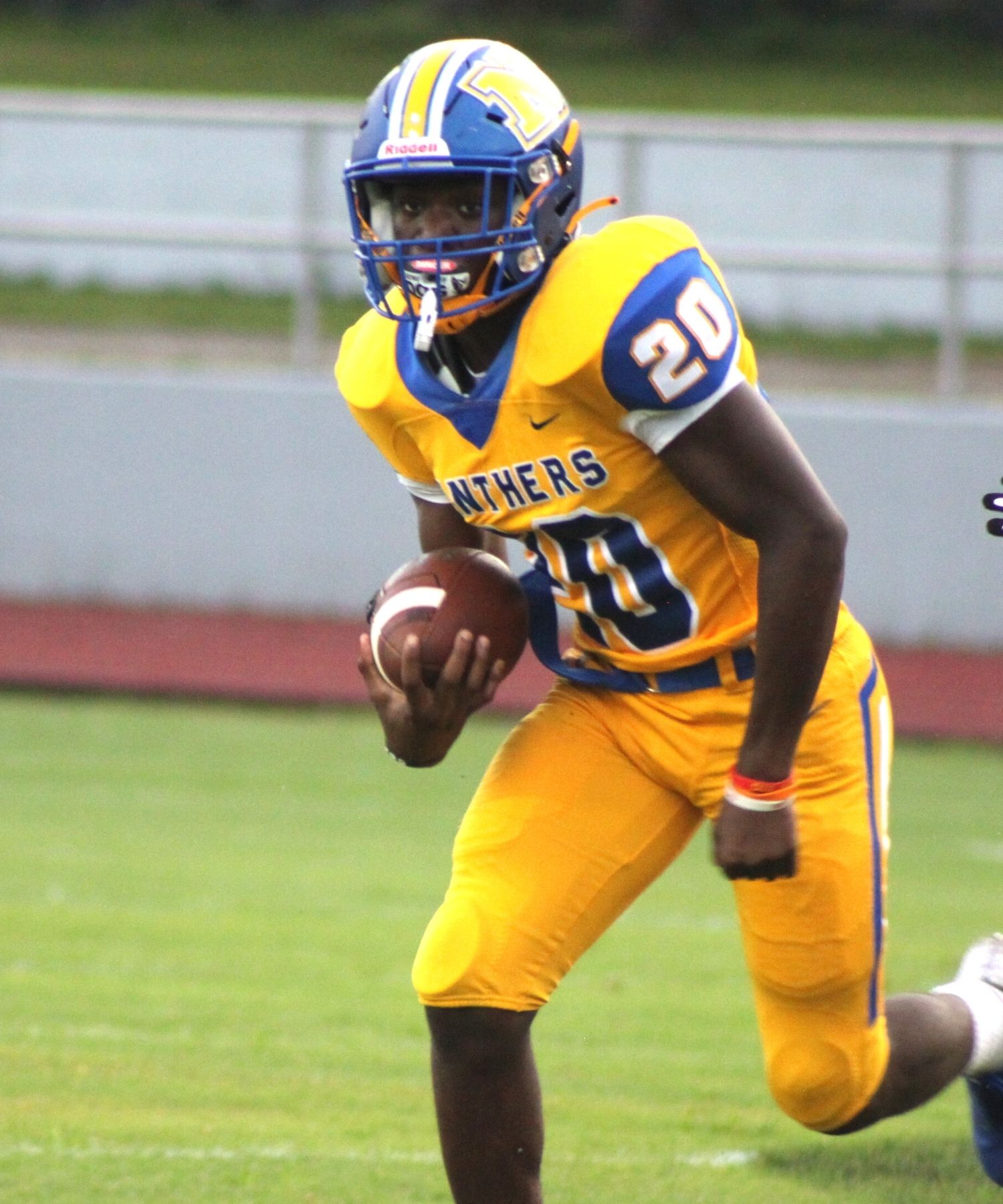 Newberry RB Keenon Johnson running with a football in his hands in a yellow jersey