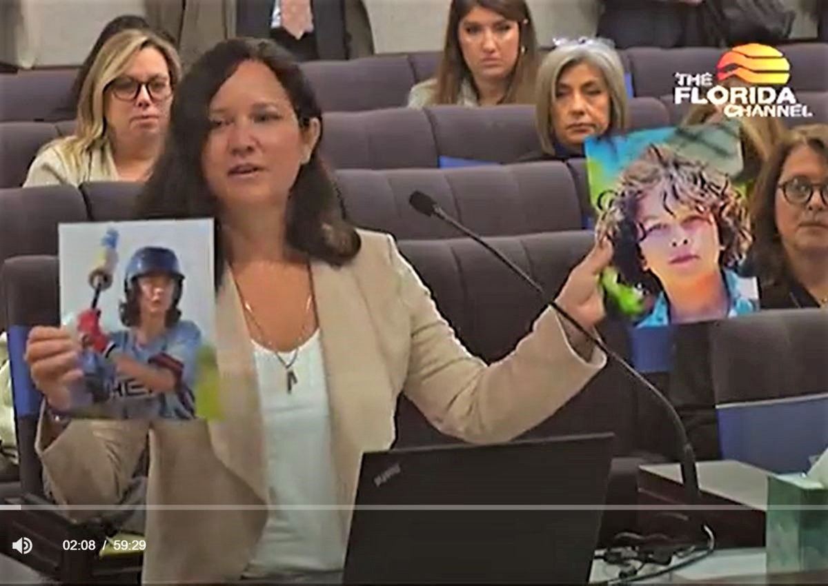 Minde Reinhart holds up photos of her boys
