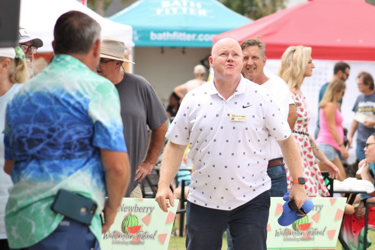 Daniel Fisher, running for school board, won the seed-spitting contest with a 41-foot launch, beating last year's record by 18 feet