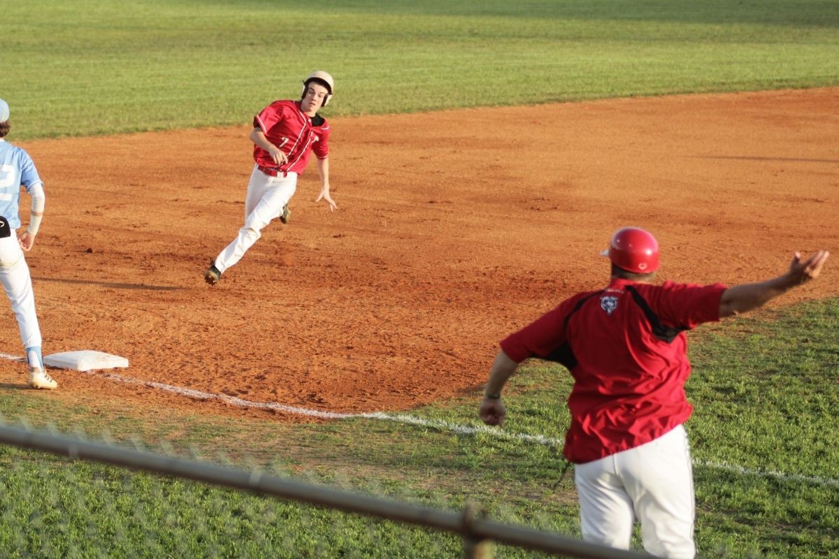Dixie County coach Shannon Smith waves Kade McCaskill for first score in 2nd inning