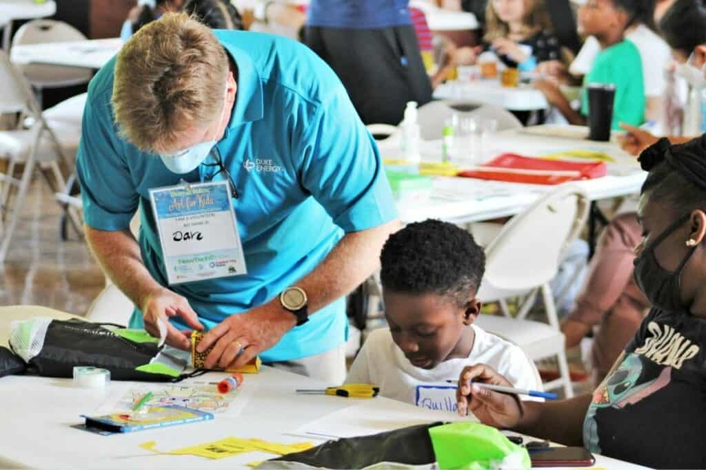 Dave TK with Duke Energy helps tape a cube together for Quilla.
