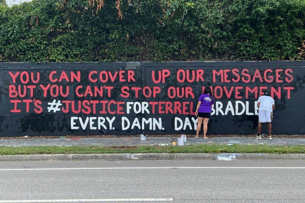 Danielle Chanzes and Terrell Bradley painting mural along SW 34th Street