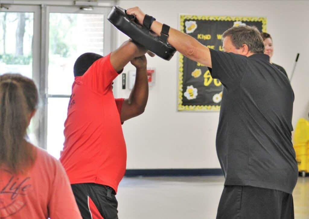 High Springs School Resource Officer Adrian Lumpkins practice self-defense with Stephen Daley during radKIDS instructor training at Newberry Elementary School.