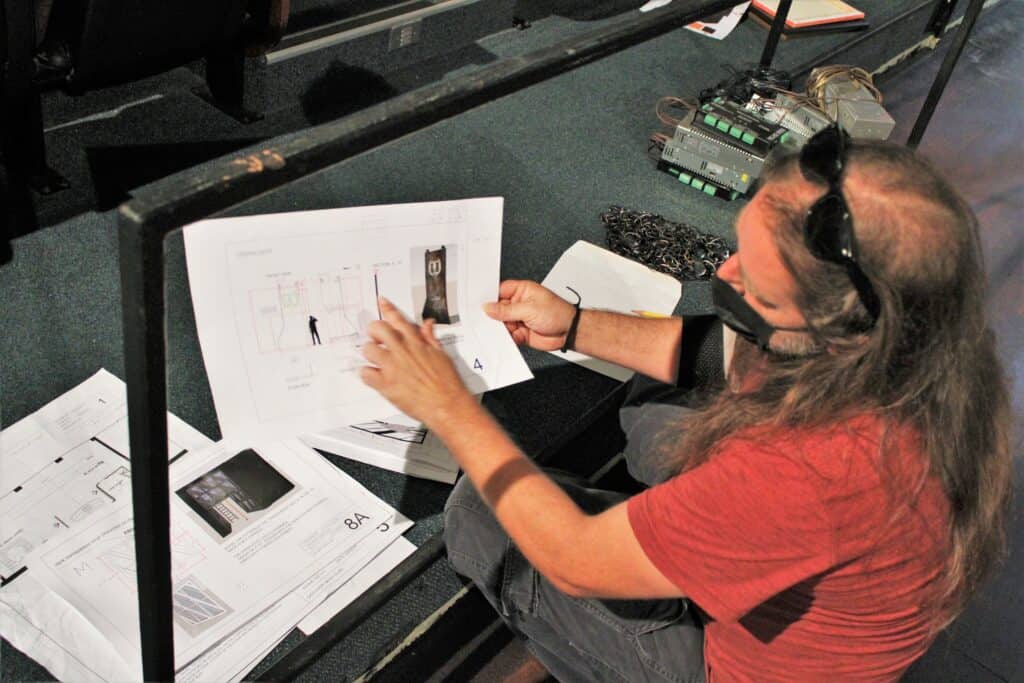 Technical Director Warren Goodwin shows the design blueprints he works from to create set designs for productions at the Hippodrome Theatre.