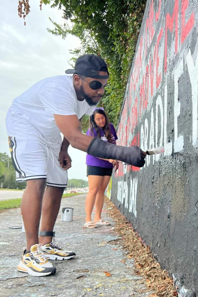 Terrell Bradley and Danielle Chanzes painting a mural along 34th Street