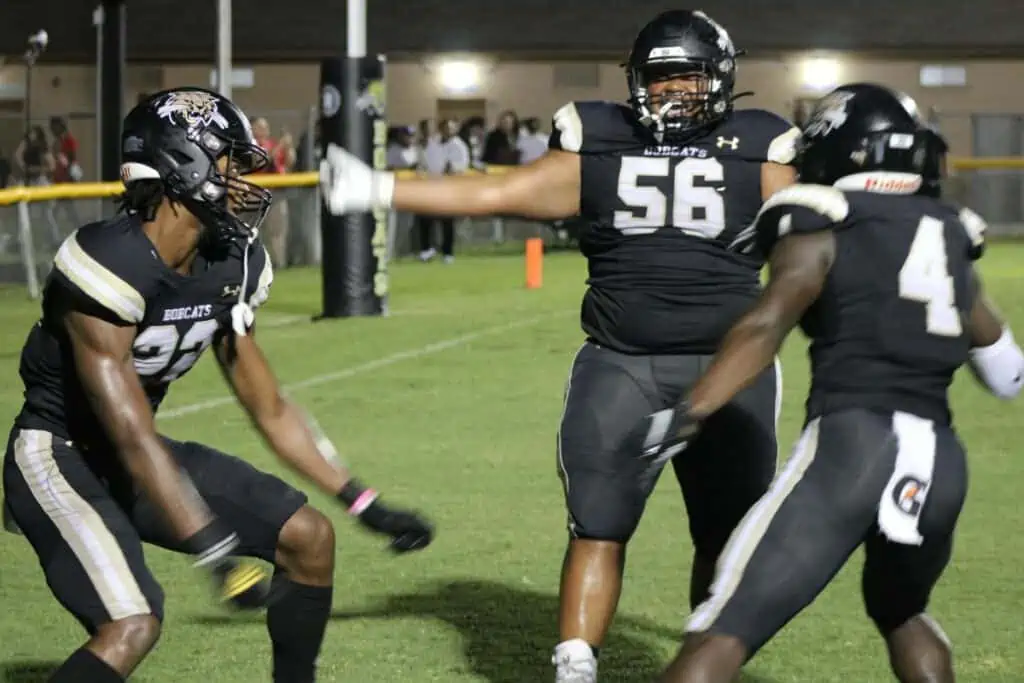 Buchholz's Jaren Hamilton (22), Naz Burney (56) and James Williams (4) celebrate one of many Bobcat scores in the first half.