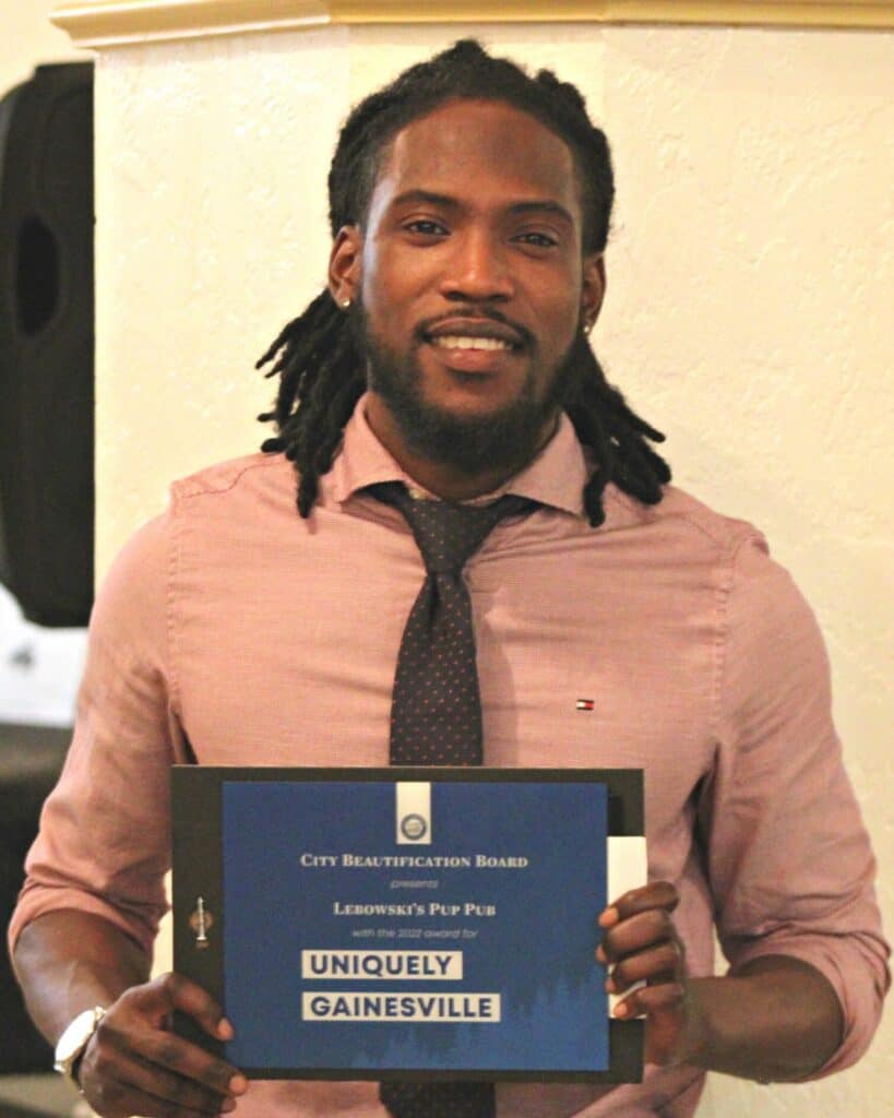 Dee Williams of Lebowski’s Pup Pub with award at GNV City Beautification Awards Ceremony.