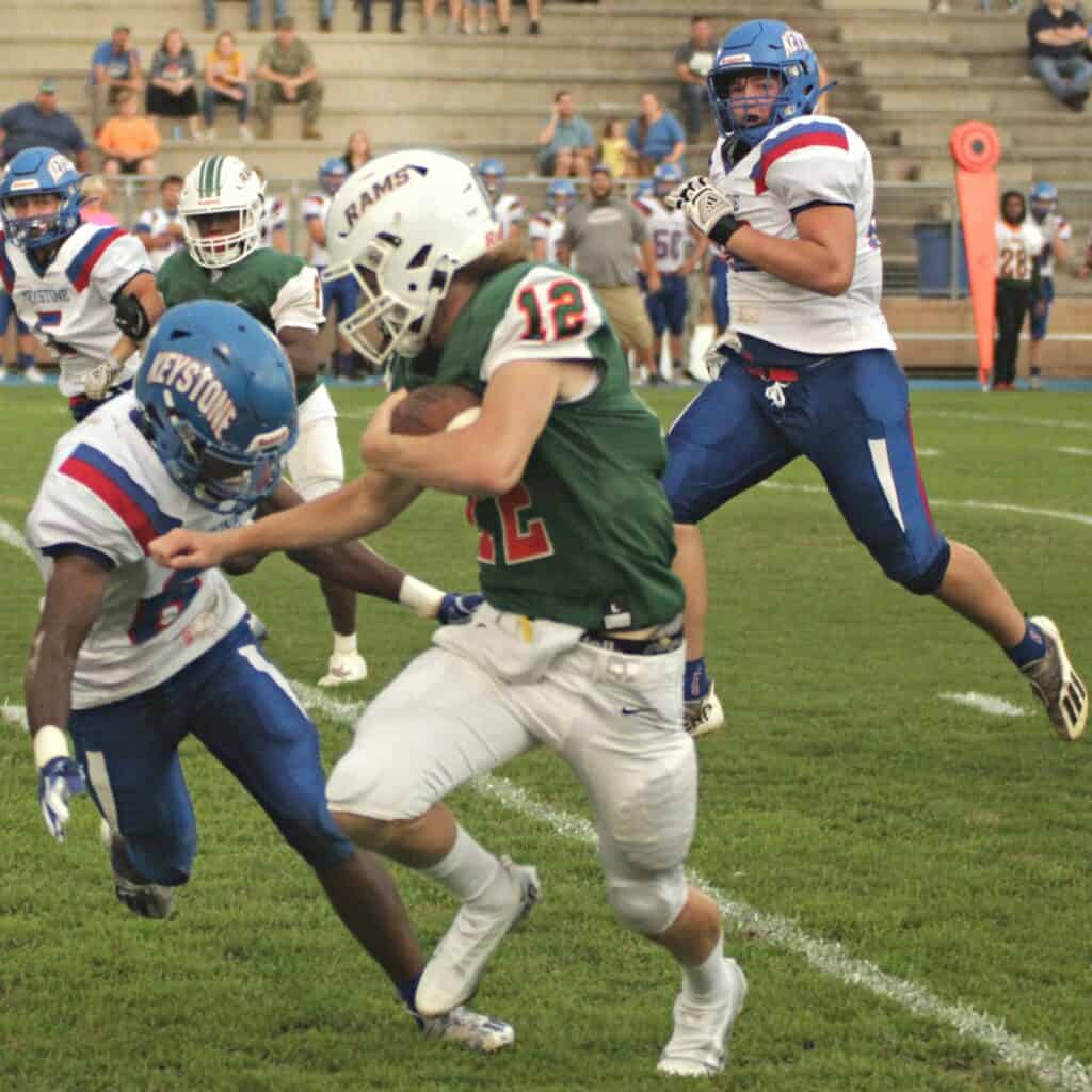 Eastside quarterback Holden Johnson scrambles past Keystone Heights' Bryar Schenck .
