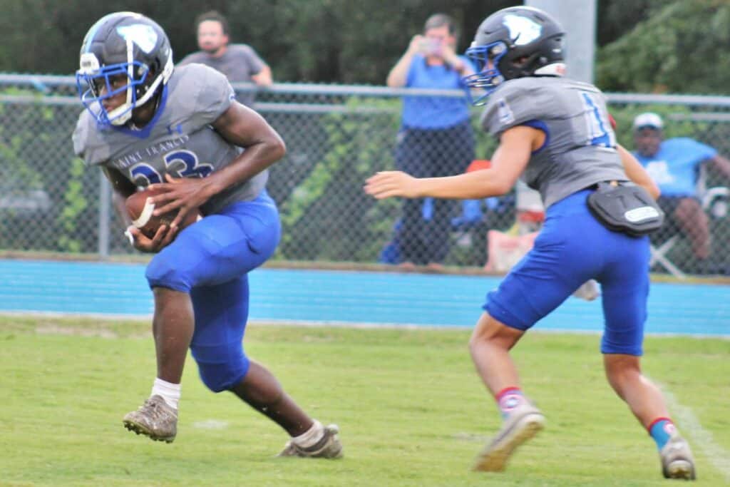 St. Francis Catholic's Devin Rollins (23) takes a handoff from Cooper Lieffers (4) on Friday.