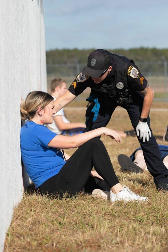 A Gainesville Police Department officer checks on Santa Fe Community College EMT student Caleigh Kiefer.