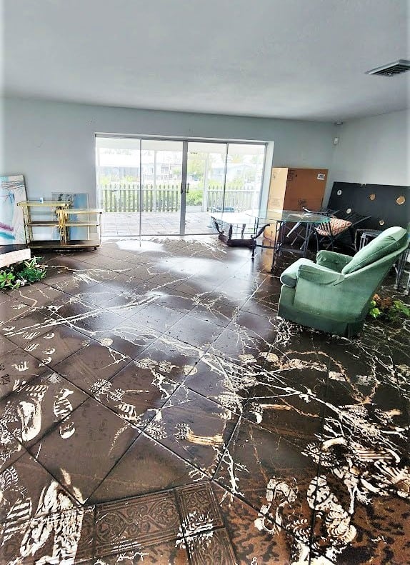 A home shows signs of the high water that flooded it, with footprints left in the mud.