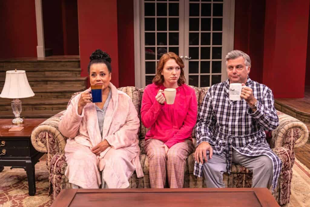 From left, Sofia-Storm, played by Joy Lynn Jacobs, Savannah Storm, played by Maggie Cramer, and Sam Storm, played by Matthew Li, drink coffee on the family couch.