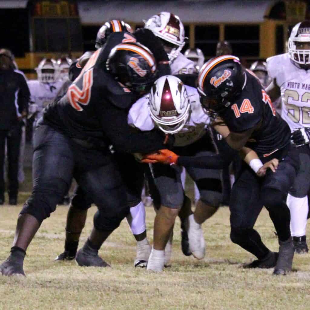 Hawthorne's Stanley Cooks (52) and Jalien Ruth (14) combine for a sack against North Marion on Friday.