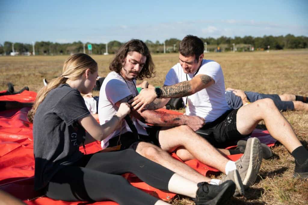 Mike Dunham's friends help him loosen a tourniquet while they await help.