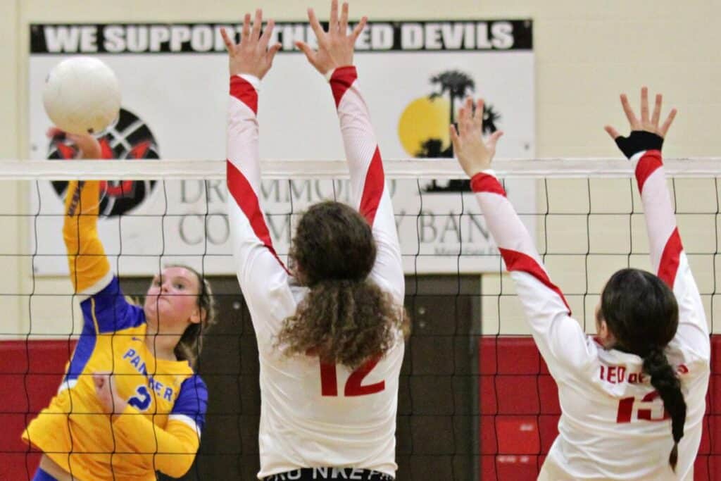 Newberry's Chloe Jones with a hit against Williston's Karley Jerrels (12) and Addison Mayes (13) on Friday.