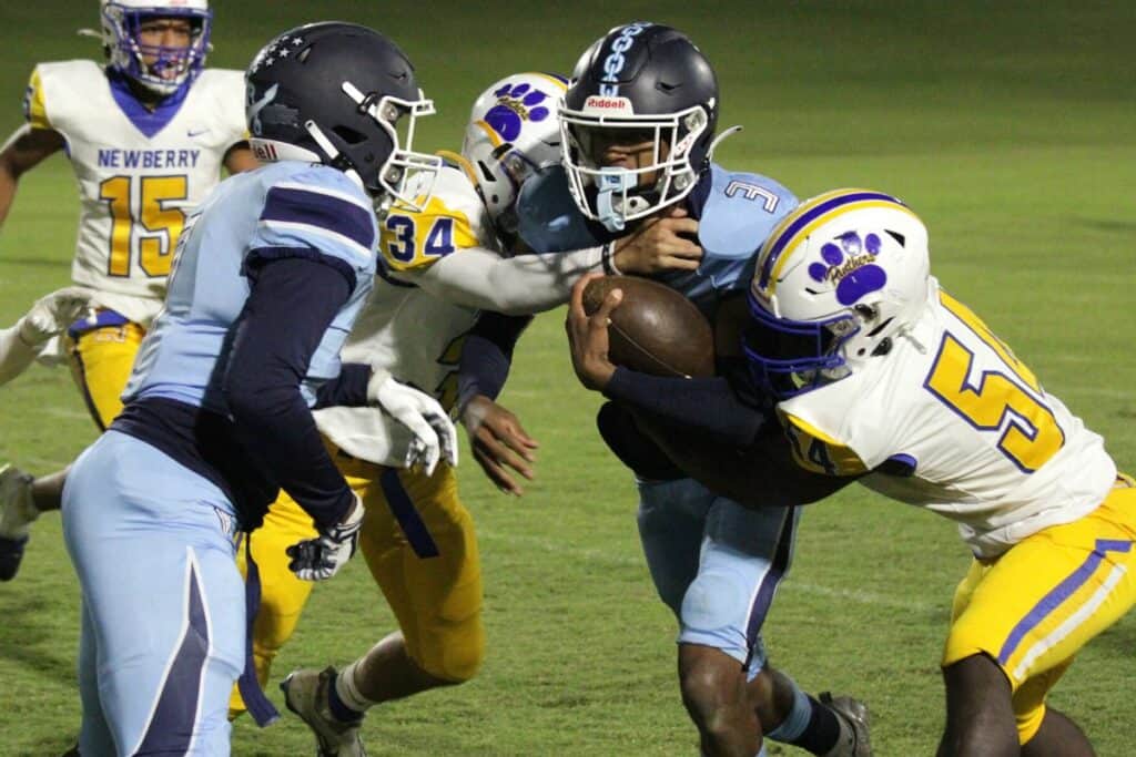 P.K. Yonge's Thomas Young III tackled by Newberry's Trenton Campbell (34) and Deshawn Davis (54) on a kickoff return Friday.