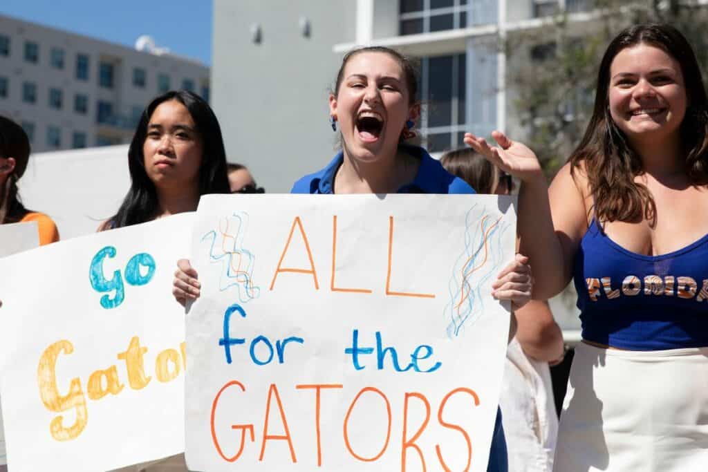 Spectators holding signs at the UF Homecoming Parade on Friday.
