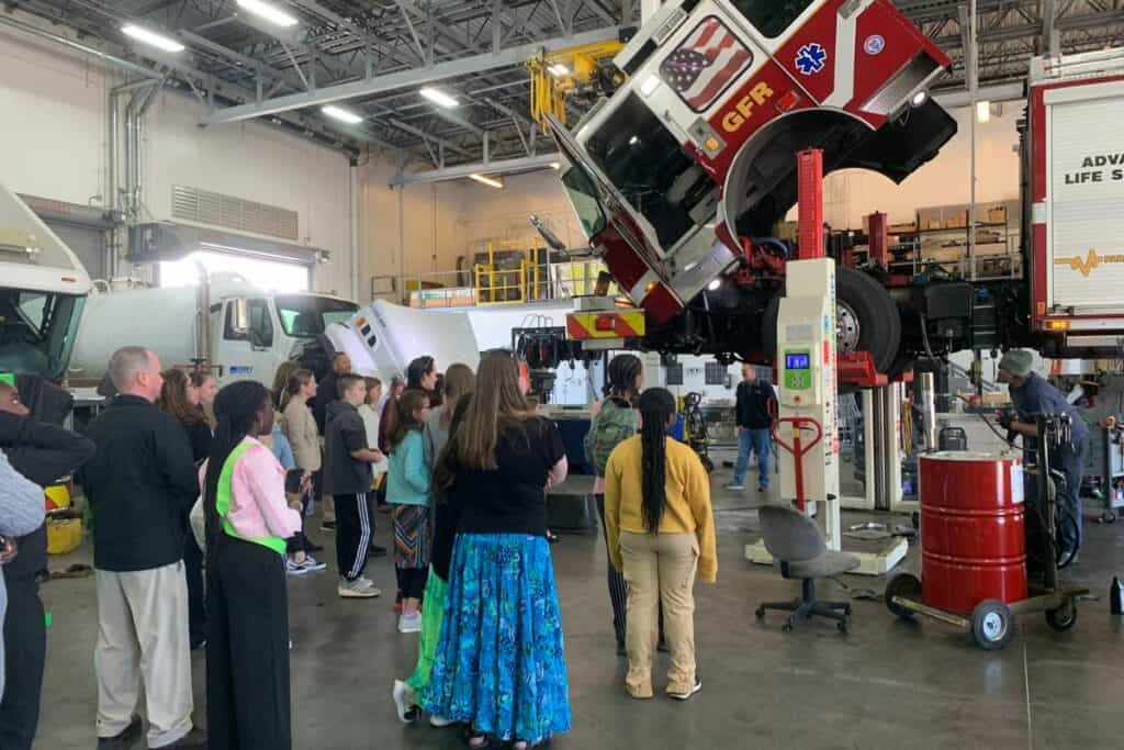 Students at fleet maintenance shop for city tour.