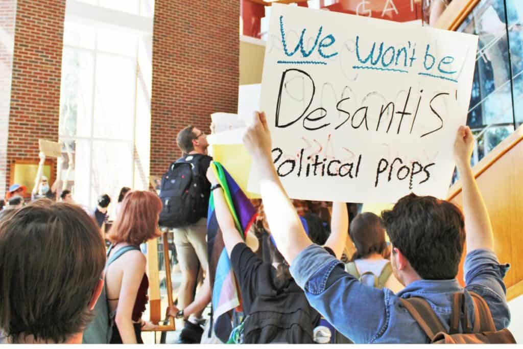 UF student protesters against Sen. Dr. Ben Sasse with DeSantis sign inside Emerson Alumni Hall on Monday.