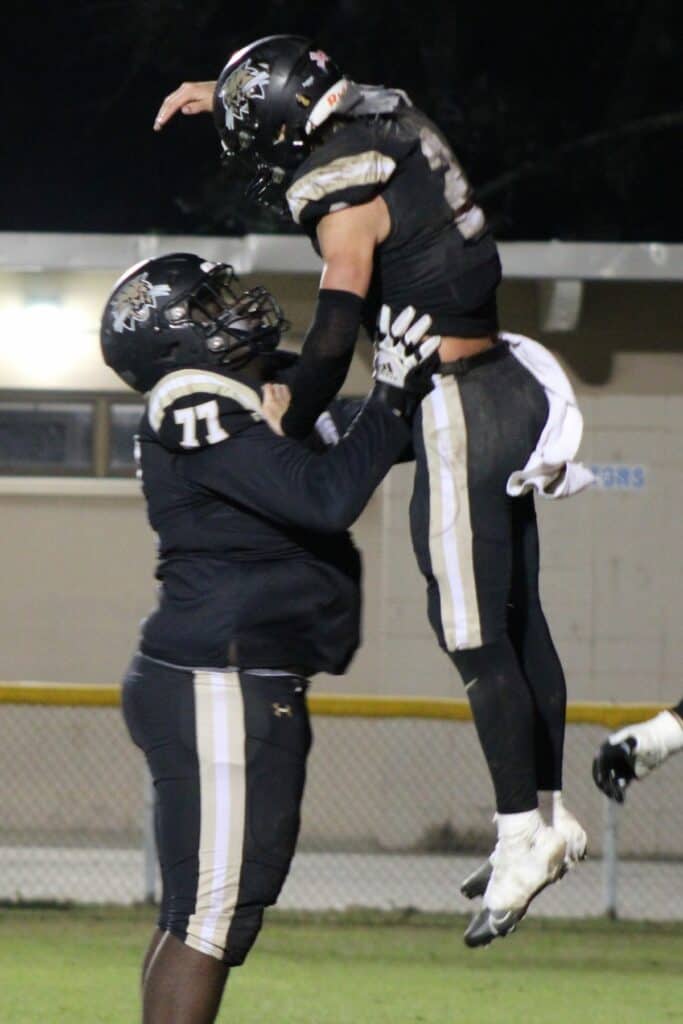 Buchholz's Perris Sylvester lifts Creed Whittemore to celebrate the quarterback's first half touchdown run against Crestview on Friday.