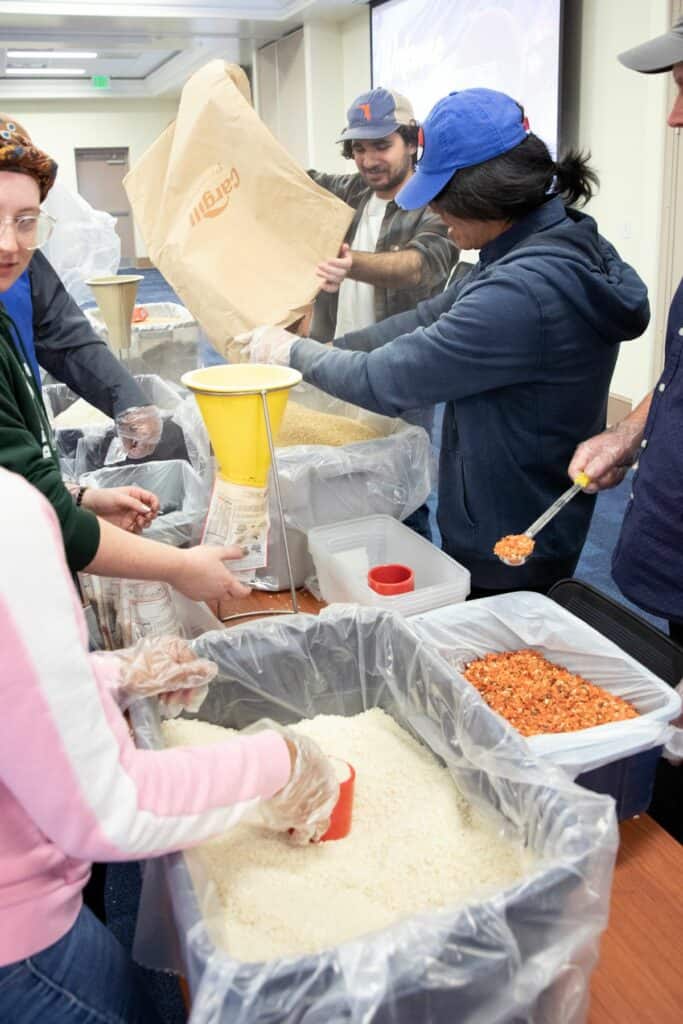 UF freshman Brett Capra, an animal science major, dumps dried soy into a bin for another volunteer.