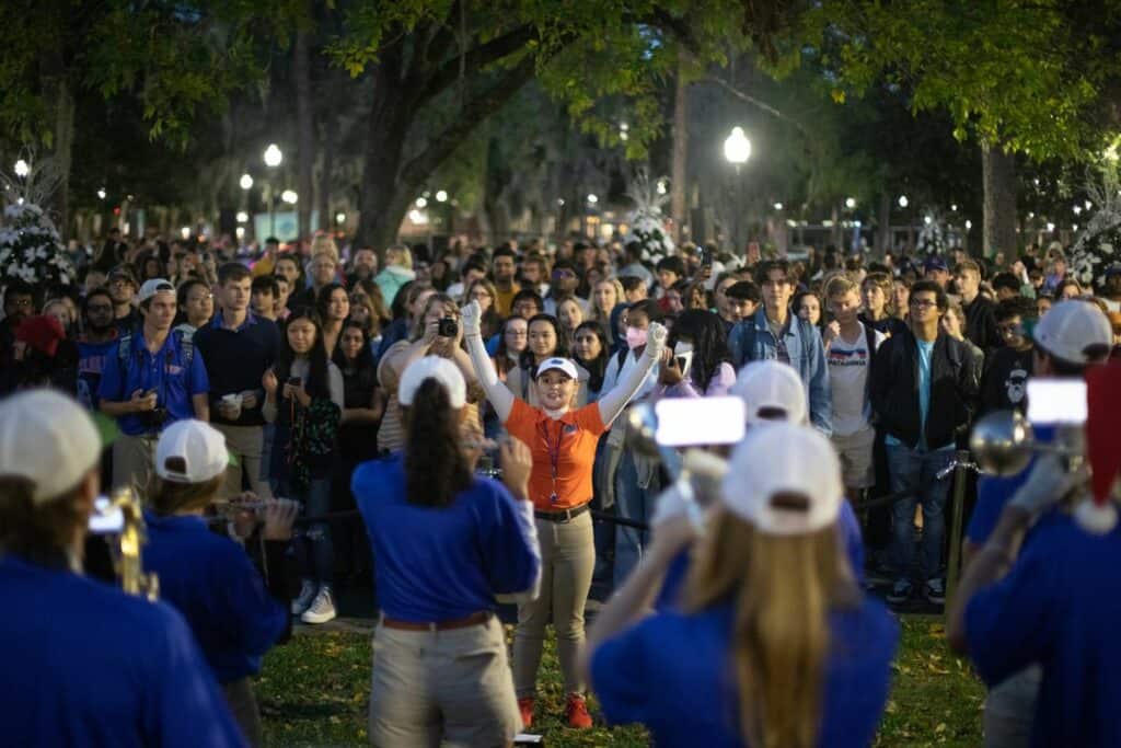 A conductor leads the UF marching band as they perform holiday carols for onlookers.