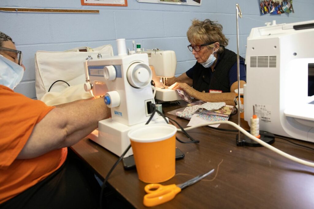 Donna Cann, right, quilts together squares of fabric. Each quilt contains 35 squares.