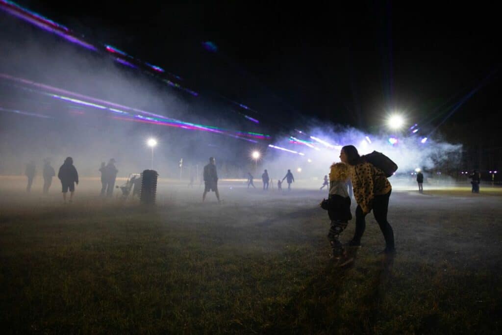 Festival attendees listened to live rock and roll music and danced among lasers and mist generated from a fog machine.