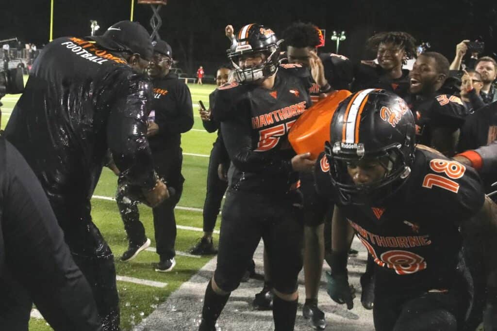 Hawthorne coach Cornelius Ingram gets doused with a bucket of ice water in the closing minutes of the Hornets championship win over Northview on Saturday.